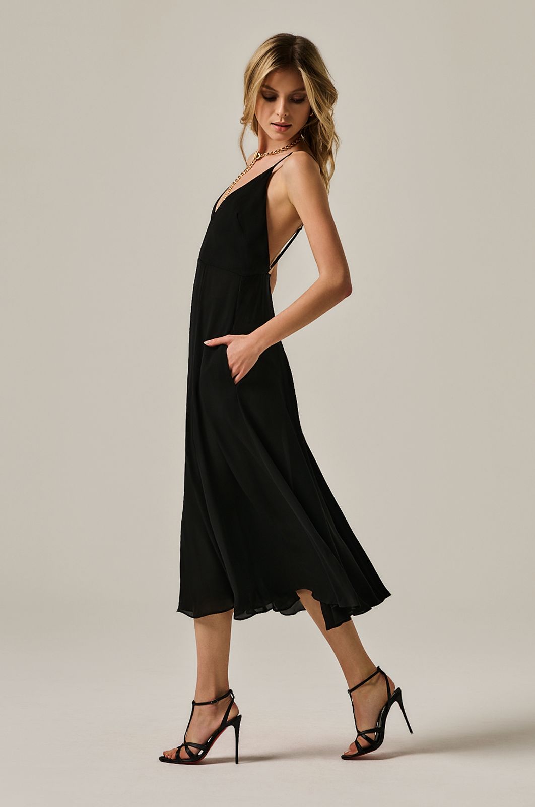 calf length flowy dress with deep plunge line at chest. double layered dress and exposed back. side view