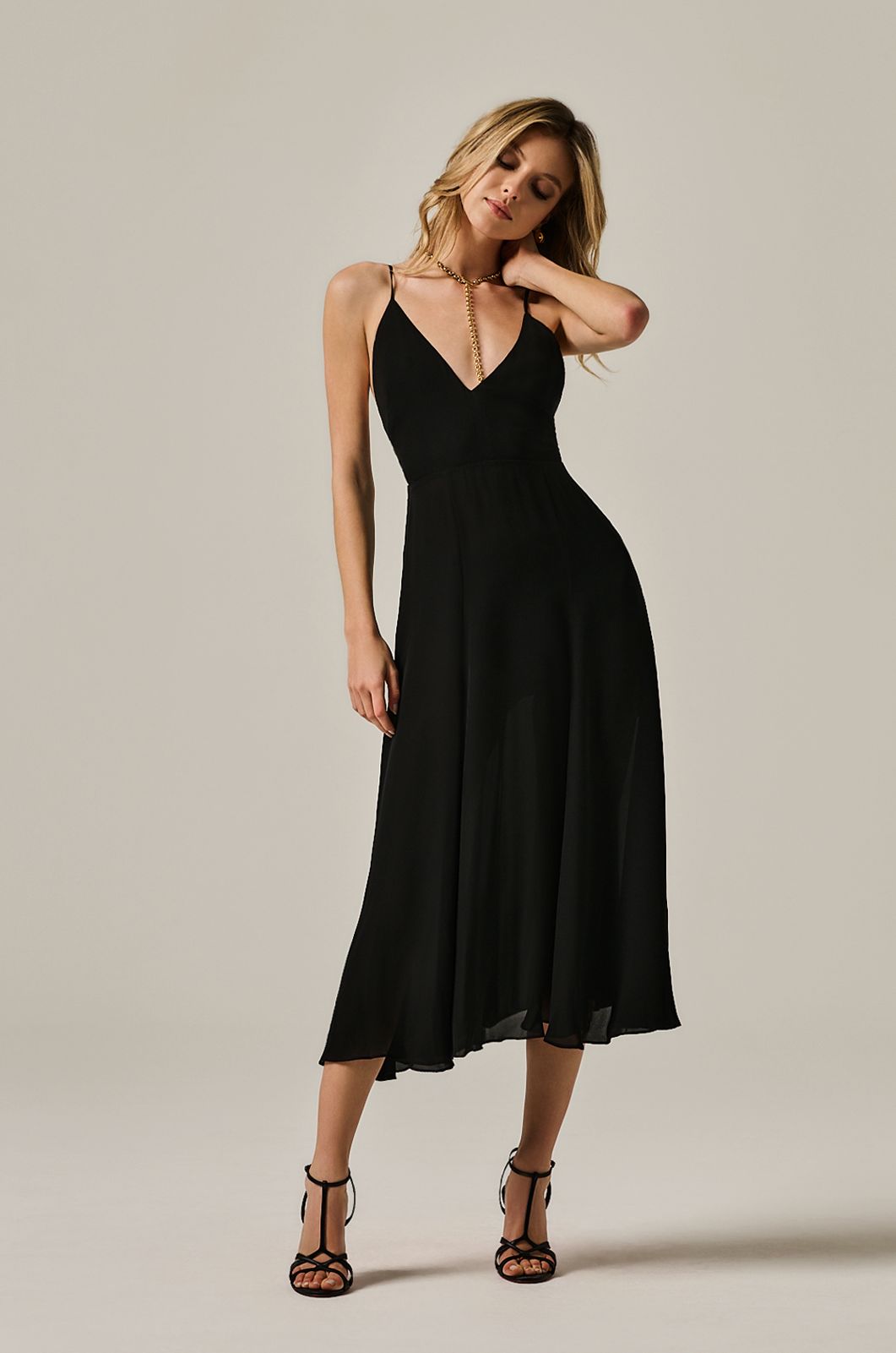 calf length flowy dress with deep plunge line at chest. double layered dress and exposed back. front view