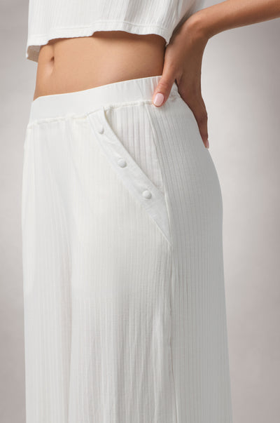 Kiki de Montparnasse Le Boy Track Pant in soft stretch rib knit with a relaxed silhouette and fabric-covered buttons at the hips, shown from the side.
