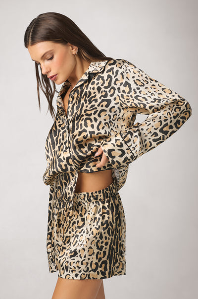 Side view of the Panthère print silk pajama top, highlighting its relaxed silhouette, lustrous silk fabric, and contrast piping details.