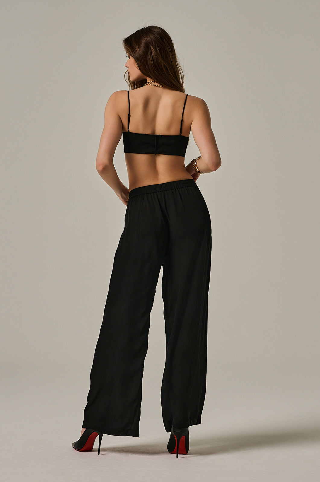 Black silk georgette bandeau top with thin adjustable straps. Black button closure on back. rear view