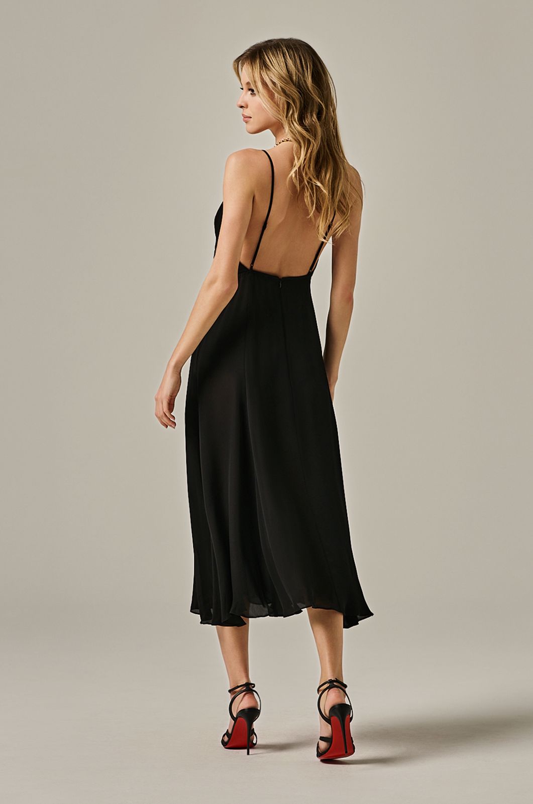 calf length flowy dress with deep plunge line at chest. double layered dress and exposed back. back view