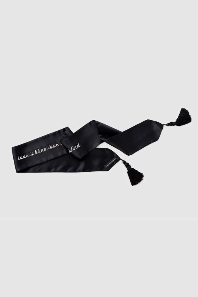 Black silk blindfold with white writing finished with tassels at each end